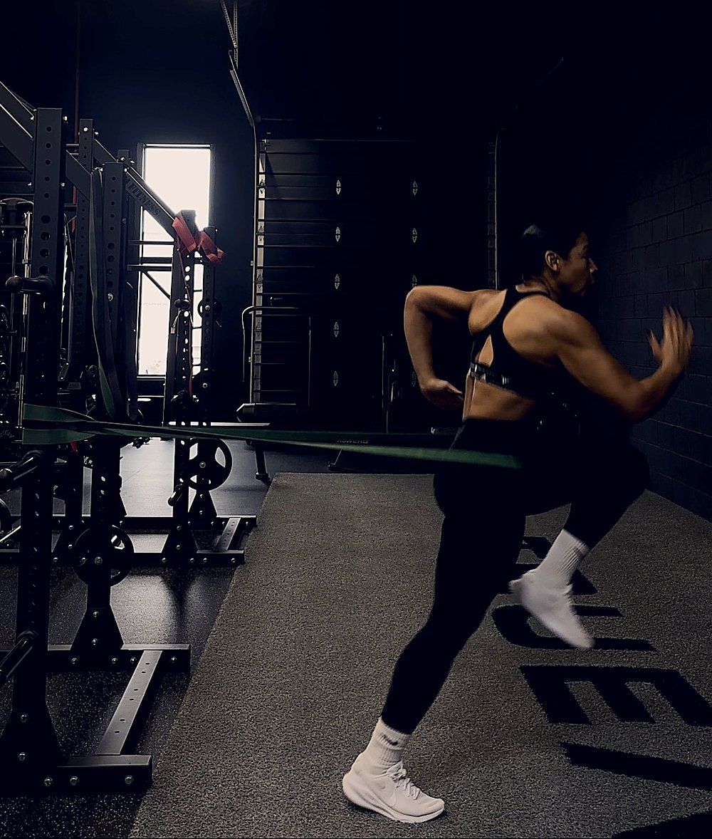 Coach Jess training with a resistance band in the gym